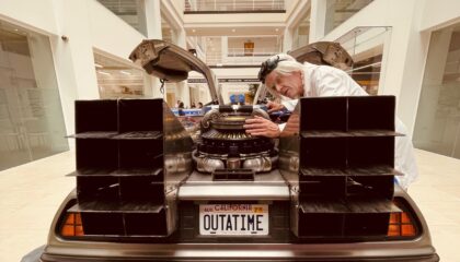 'Doc' from back to the future inspects the delorian